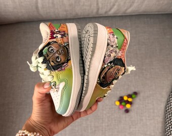 May include: Custom-painted trainers with a colourful design. The shoes feature a white sole, a gradient of green and yellow, and a portrait of a character. The laces are light green. The trainers are held up in the air.