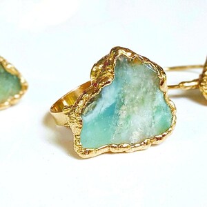 A Solid 14k Gold ring featuring a large raw and uncut Aqua blue Peruvian Opal