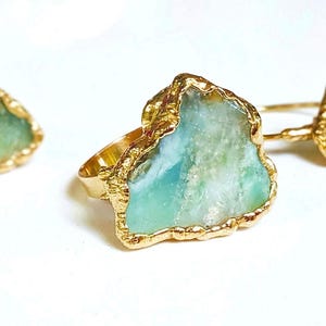 A large raw Peruvian Opal ring set in 18k Gold on a woman's finger