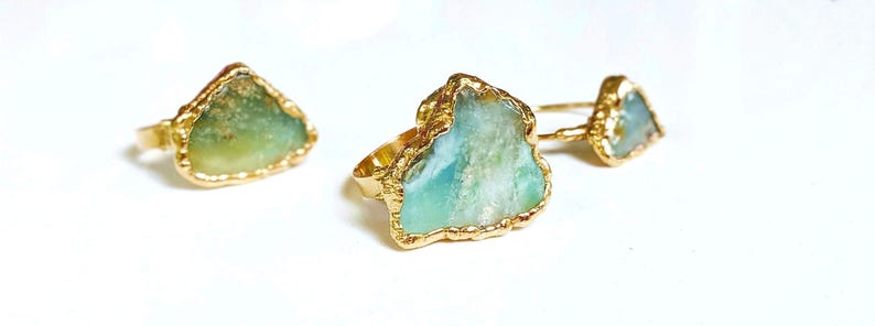 A large raw Peruvian Opal ring set in 18k Gold on a woman's finger