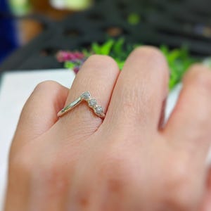 A rough diamond Chevron bridal ring in 18k Gold on a womans hand