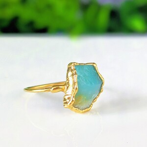 A Solid 14k Gold ring featuring a large raw and uncut Aqua blue Peruvian Opal