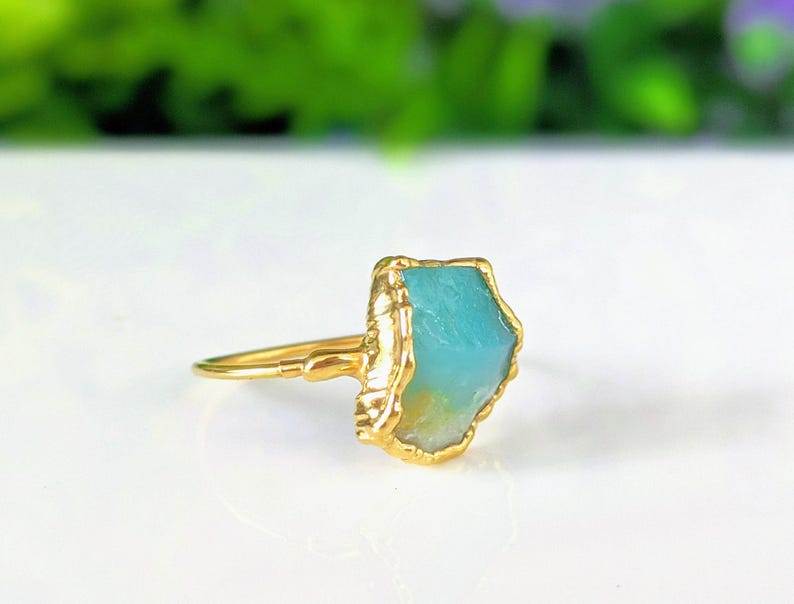 A Solid 14k Gold ring featuring a large raw and uncut Aqua blue Peruvian Opal