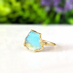 A Solid 14k Gold ring featuring a large raw and uncut Aqua blue Peruvian Opal