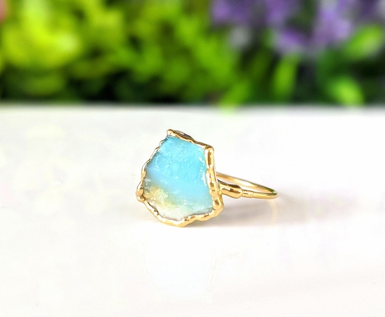 A Solid 14k Gold ring featuring a large raw and uncut Aqua blue Peruvian Opal