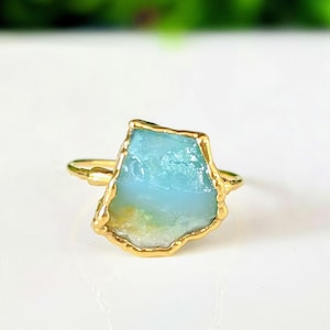 A Solid 14k Gold ring featuring a large raw and uncut Aqua blue Peruvian Opal