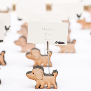Puede incluir: Porta tarjetas de mesa de madera con forma de perro con una tarjeta blanca que dice "Haylee May" y "Head Table".