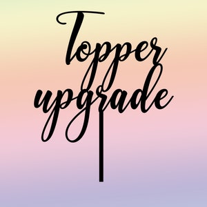 May include: Black acrylic cake topper with the words "topper upgrade" in a cursive font.