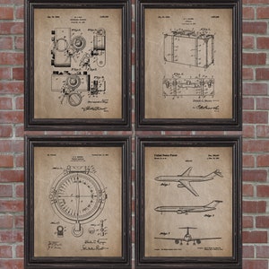 May include: Four framed vintage patent prints. The prints feature detailed black and white technical drawings of a camera, suitcase, compass, and airplane. The frames are dark brown, and the background is a brick wall.