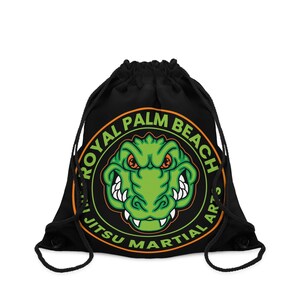 May include: Black drawstring bag with an orange and green logo. The logo features a cartoon alligator with the text "Royal Palm Beach Jiu Jitsu Martial Arts".