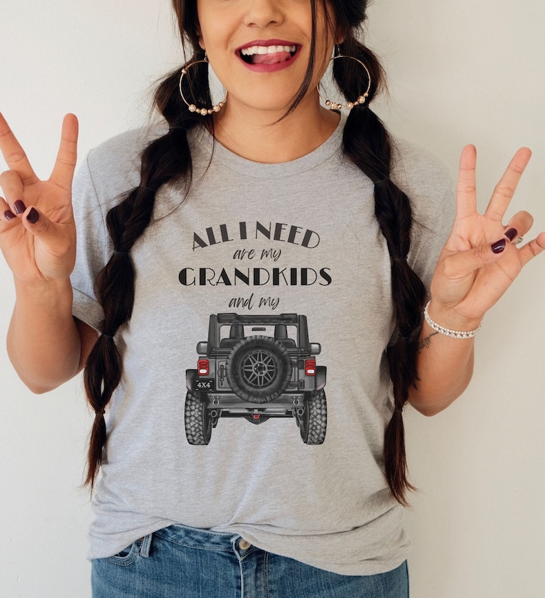 Puede incluir: Camiseta gris con el texto "All I need are my grandkids and my" con un gr&aacute;fico de Jeep negro.