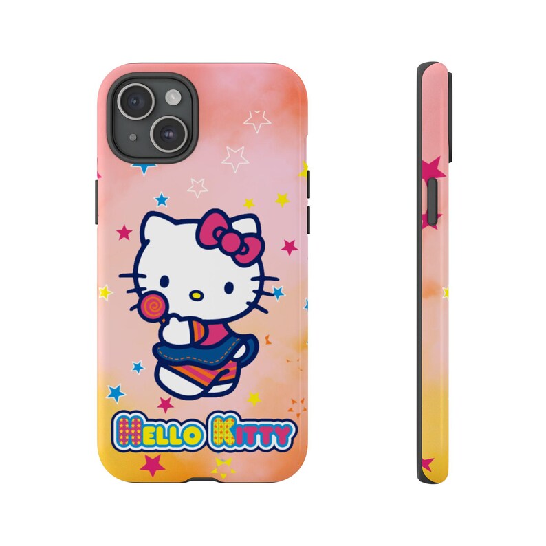 May include: A phone case with a Hello Kitty design, holding a lollipop, set against a pink and yellow gradient background with star accents. The case has a black camera module and the words "HELLO KITTY".