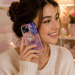 May include: A smartphone case featuring a colorful illustration of the character Hello Kitty sitting in a bedroom at night. The design includes a starry sky visible through a window, a bed, and soft purple and blue tones across the surface.