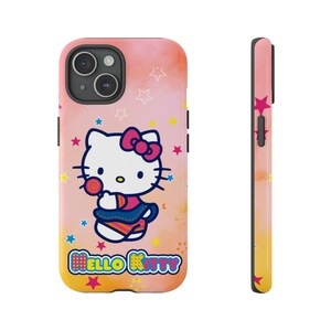 May include: A phone case with a Hello Kitty design, holding a lollipop, set against a pink, orange, and yellow gradient. The case is decorated with stars and the words "Hello Kitty". The side view shows a matching design.