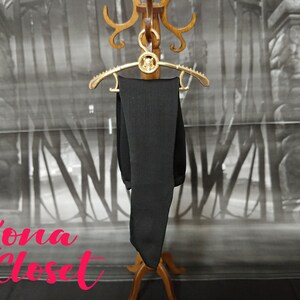 May include: A black pair of tights hanging on a gold hanger against a backdrop of a gray and white patterned wall. The text "Kona Closet" is visible in the bottom left corner of the image.