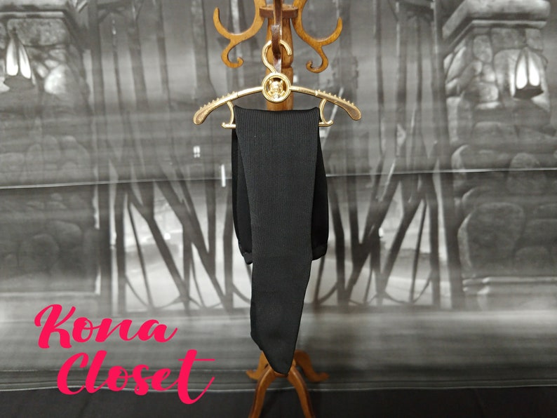 May include: A black pair of tights hanging on a gold hanger against a backdrop of a gray and white patterned wall. The text "Kona Closet" is visible in the bottom left corner of the image.