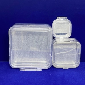 May include: Three clear plastic square boxes with lids, nested inside each other. The boxes are empty.