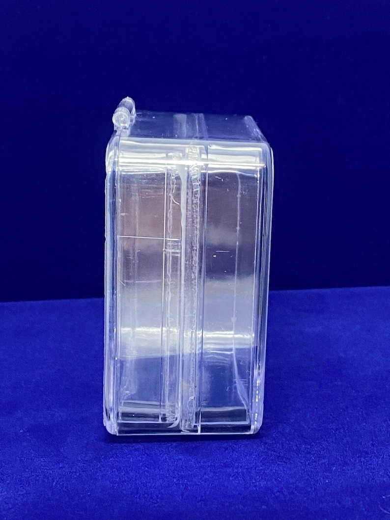 May include: A clear plastic storage box with a hinged lid. The box is empty and has a rectangular shape.