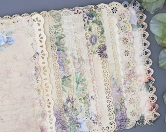 May include: A stack of vintage-style paper with lace trim and floral designs. The paper has a cream background with a light brown grid pattern. The paper is perfect for scrapbooking, card making, or other paper crafts.