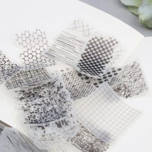 Könnte beinhalten: Ein Satz transparenter Blätter mit verschiedenen schwarz-weißen geometrischen Mustern, darunter Gitter, Punkte und Linien. Die Blätter eignen sich perfekt zum Hinzufügen von Textur und Design zu Bastel- und Kunstprojekten.