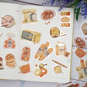 May include: A set of 24 stickers featuring various bakery and bread-making themed illustrations. The stickers are printed on clear vinyl and feature a variety of designs, including loaves of bread, pastries, kitchen tools, and other baking-related items. The stickers are perfect for adding a touch of whimsy to your planner, journal, or laptop.