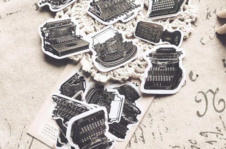 May include: A collection of vintage typewriter stickers in black and white. The stickers are printed on white paper and have a distressed look. The stickers feature different types of typewriters, including a manual typewriter, an electric typewriter, and a portable typewriter.