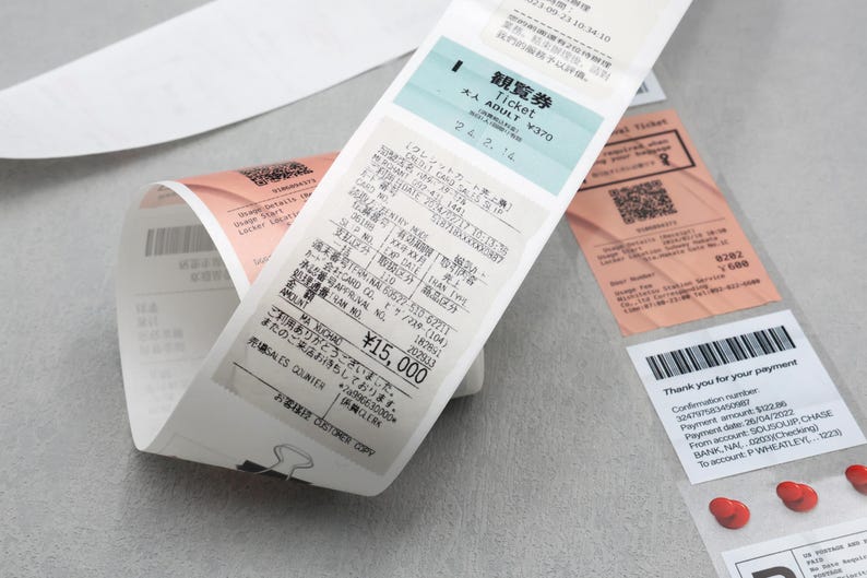 May include: A white receipt with black text and a blue and white ticket with the text "Ticket Adult &yen;370" and "24 2.14". The receipt shows a total of &yen;15,000.