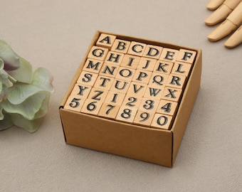 May include: A wooden box filled with alphabet and number blocks. The blocks are arranged in alphabetical and numerical order. The box is made of brown cardboard.