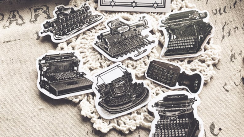May include: A set of eight vintage typewriter stickers in black and white. The stickers feature different styles of typewriters, including a manual typewriter, an electric typewriter, and a vintage typewriter with a keyboard.