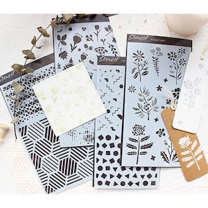 May include: A selection of stencils featuring geometric and floral patterns. The stencils are light blue and black, with the word "Stencil" printed on them. There are also some tags with floral designs.