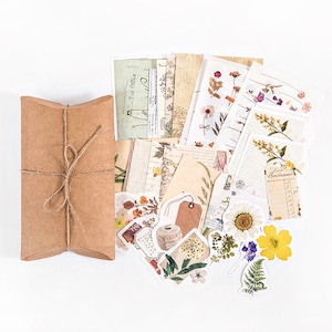 May include: A brown paper envelope tied with twine, filled with a variety of decorative paper, stickers, and ephemera featuring floral designs and vintage-inspired patterns.