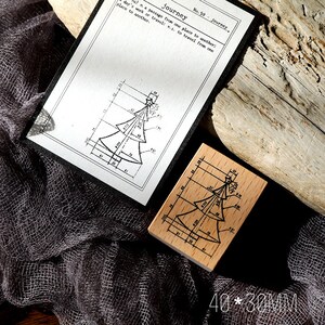 May include: A wooden stamp with a Christmas tree design and a matching print on a white card. The stamp measures 40mm x 30mm. The card has the word "journey" printed on it.
