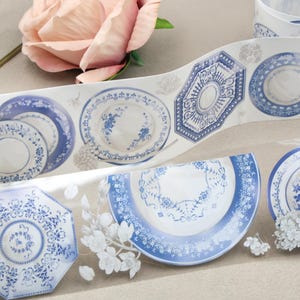 May include: A set of three ceramic mugs with a speckled, cream-coloured glaze. Each mug features a different hand-painted floral design in shades of blue, green, and yellow. The mugs have a simple, rounded shape.