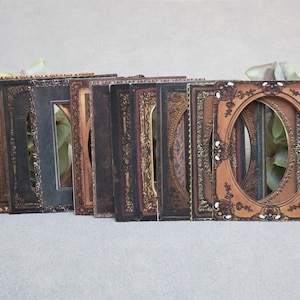 以下が含まれることがあります： 茶色、金、黒の色合いの、ヴィンテージスタイルの写真フレームのコレクション。フレームには装飾的なディテールがあり、楕円形または長方形の開口部があります。フレームは一列に並んでおり、ディスプレイまたは装飾的な配置を示唆しています。
