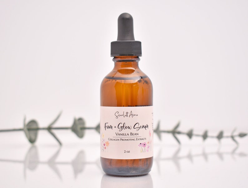 Puede incluir: Una botella de vidrio marr&oacute;n con un gotero lleno de un l&iacute;quido transparente. La etiqueta dice "Scarlet Aeu Firm + Glow Serum Vanilla Bean Collagen Promoting Extracts 2 oz."