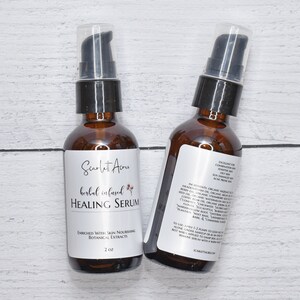 May include: Two amber glass bottles with black pump tops filled with a clear liquid. The bottles are labeled "Scarlet Acru herbal infused HEALING SERUM" and "ENRICHED WITH SKIN NOURISHING BOTANICAL EXTRACTS 2 oz".