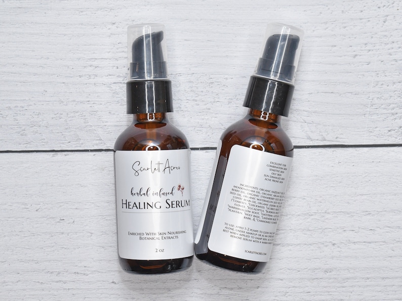 May include: Two amber glass bottles with black pump tops filled with a clear liquid. The bottles are labeled "Scarlet Acru herbal infused HEALING SERUM" and "ENRICHED WITH SKIN NOURISHING BOTANICAL EXTRACTS 2 oz".