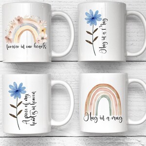 Puede incluir: Cuatro tazas de cer&aacute;mica blanca con diferentes dise&ntilde;os. Una taza presenta un arco&iacute;ris y un dise&ntilde;o floral con el texto "forever in our hearts". Otra tiene una flor azul y el texto "Hug in a Mug". La tercera taza tiene una flor azul y el texto "A piece of my heart is in heaven". La &uacute;ltima taza tiene un arco&iacute;ris y el texto "Hug in a mug."
