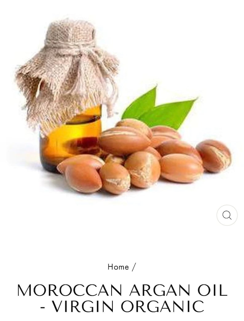May include: A glass bottle of Moroccan argan oil with a burlap covering and a pile of argan nuts in front of it.