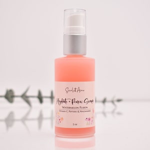 Op de afbeelding: Een roze glazen fles met een witte pomp en een etiket met de tekst "Hydrate + Renew Serum Watermeloen Fusion Vitamine C, Peptiden & Niacinamide 2 oz".