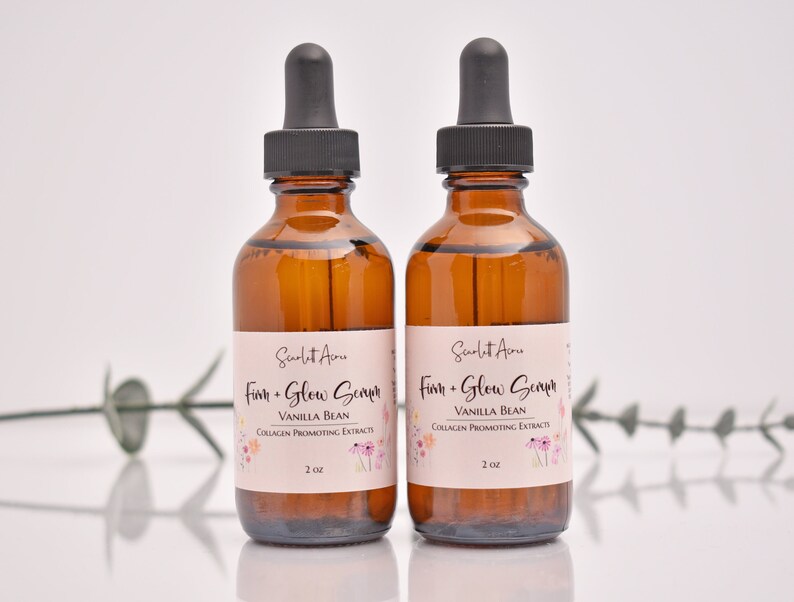 Puede incluir: Dos botellas de vidrio &aacute;mbar con goteros, etiquetadas "Scarlet Ame Firm + Glow Serum Vanilla Bean Collagen Promoting Extracts 2 oz."