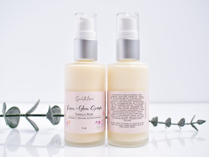 May include: Two 2-ounce bottles of a clear serum labeled "Renew + Glow Serum Vanilla Rose Vitamin C, Peptides & Niacinamide". The bottles have silver pumps and are on a white surface with a green plant in the background.