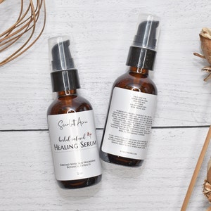 May include: Two amber glass bottles with black pump tops filled with a clear liquid. The bottles are labeled "Scarlet Acres Herbal Infused Healing Serum" and contain 2 fl oz. The bottles are on a white wooden surface.