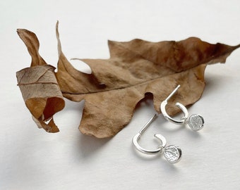 Tiny silver hoop earrings with charm