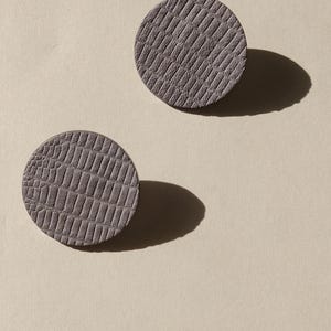 Make a bold statement with these oversized grey raptile embossed leather stud earrings, designed for lovers of minimalist style with a modern urban edge. Crafted from exceptionally soft genuine leather, these large yet ultra-lightweight earrings offer striking presence without compromising comfort.