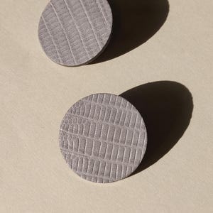 Make a bold statement with these oversized grey raptile embossed leather stud earrings, designed for lovers of minimalist style with a modern urban edge. Crafted from exceptionally soft genuine leather, these large yet ultra-lightweight earrings offer striking presence without compromising comfort.