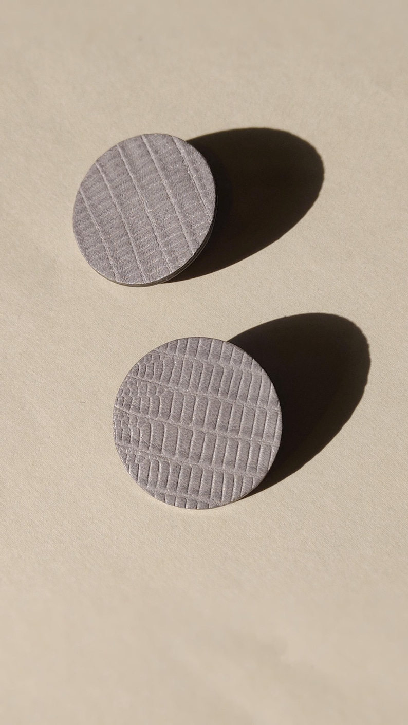Make a bold statement with these oversized grey raptile embossed leather stud earrings, designed for lovers of minimalist style with a modern urban edge. Crafted from exceptionally soft genuine leather, these large yet ultra-lightweight earrings offer striking presence without compromising comfort.