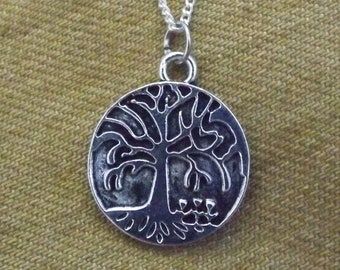 May include: A silver chain necklace with a round pendant featuring a detailed tree of life design.