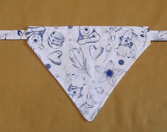 May include: White cotton bandana with a blue and white print of Winnie the Pooh characters, hearts, and flowers. The bandana has a blue trim and a tie closure.