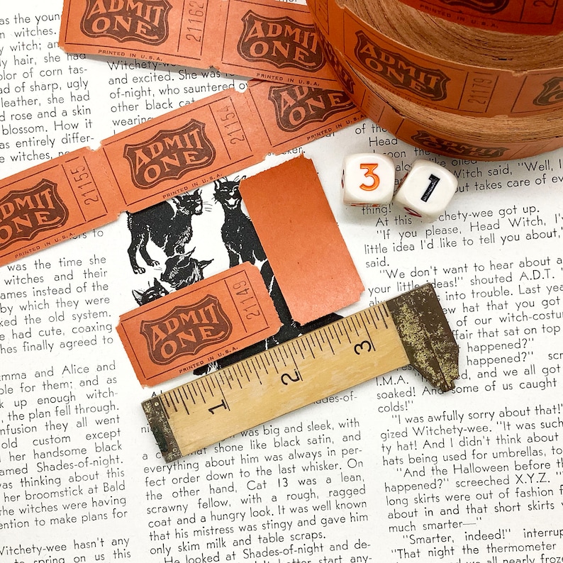 Puede incluir: Una colecci&oacute;n de boletos vintage "ADMIT ONE" impresos en naranja y marr&oacute;n con texto negro. Los boletos presentan una ilustraci&oacute;n de un gato negro. Los boletos est&aacute;n dispuestos en una p&aacute;gina de libro con una regla y dados.